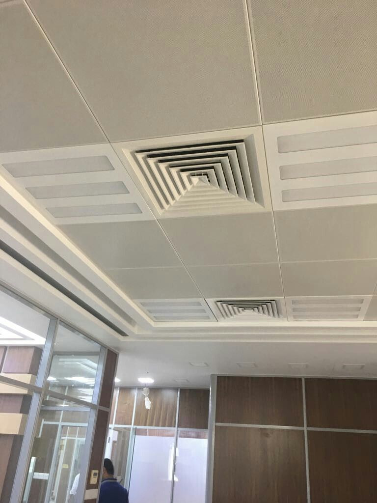 Difusores de insuflamento e retorno instalados em forro de circulação hospitalar.